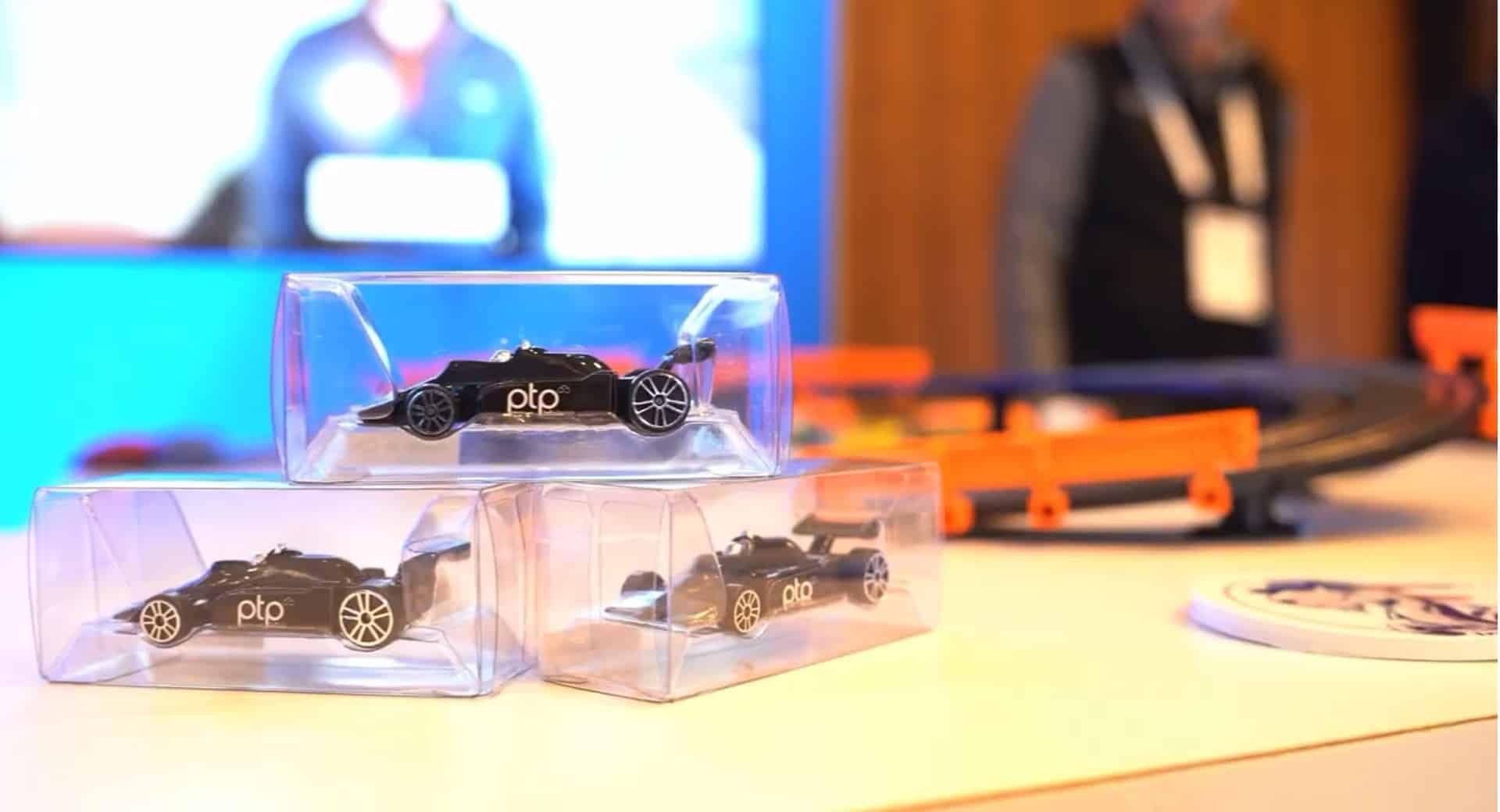 PTP promotional model cars on display at a mini racetrack setup at the Bio-IT World Conference & Expo 2024.