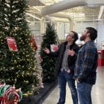 Alex and Ben from the PeakPlus team evaluating a pre-lit Christmas tree at a charity event hosted by Matthew 25: Ministries.
